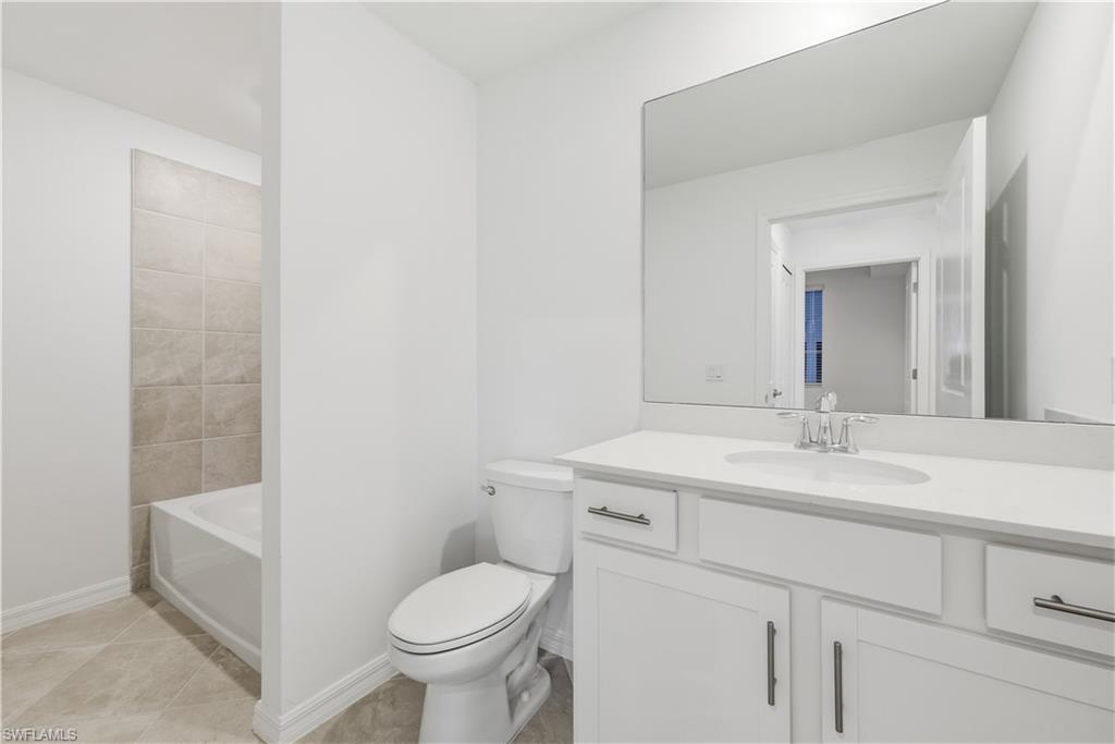 5555 Double Eagle Circle, Unit 3915 Ave Maria, FL 34142 - Photo 19 of 33 a bathroom with a granite countertop toilet sink and mirror