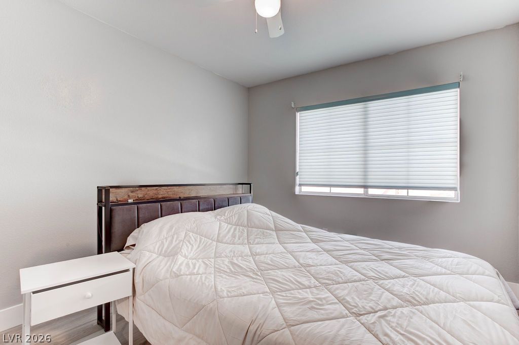 1 Rising Sun Court Henderson, NV 89074 - Photo 26 of 47 A well-lit bedroom offering a cozy retreat with thoughtful window treatments and a classic ceiling fixture.