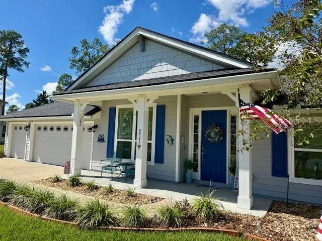 a view of a house with potted plants and a yard in front of it