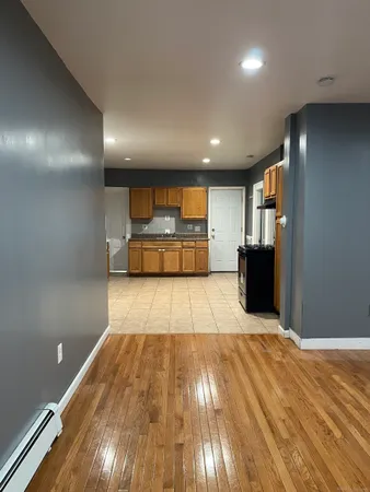 a view of kitchen with refrigerator and wooden floor