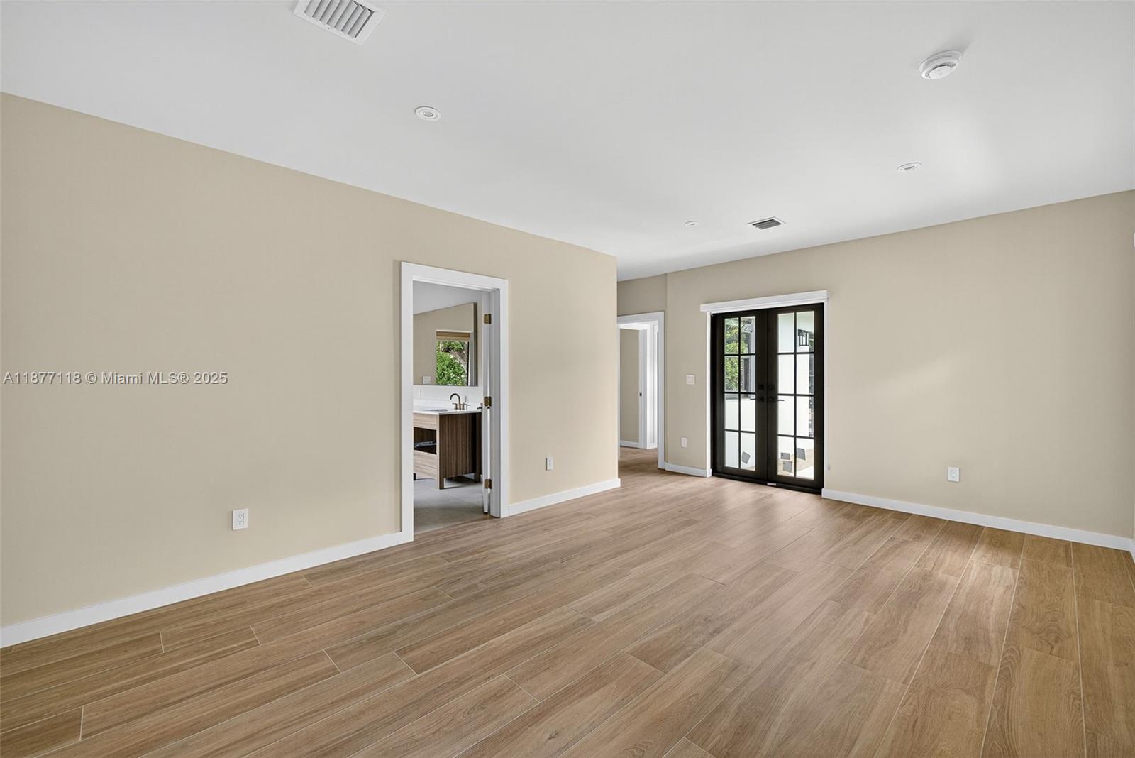 635 Bird Road Coral Gables, FL 33146 - Photo 12 of 25 a view of an empty room with window and wooden floor