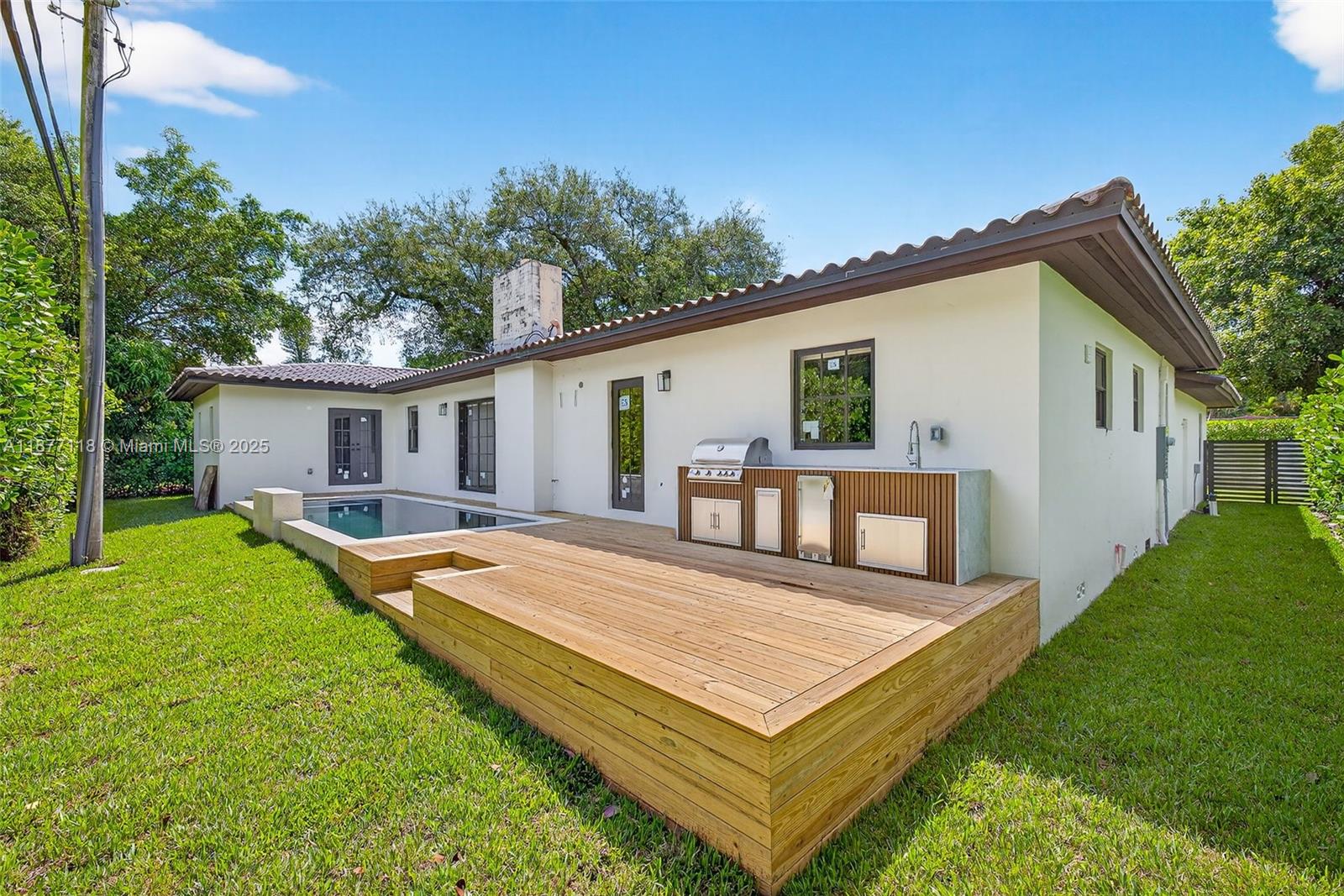 635 Bird Road Coral Gables, FL 33146 - Photo 23 of 25 a view of a house with pool and a yard
