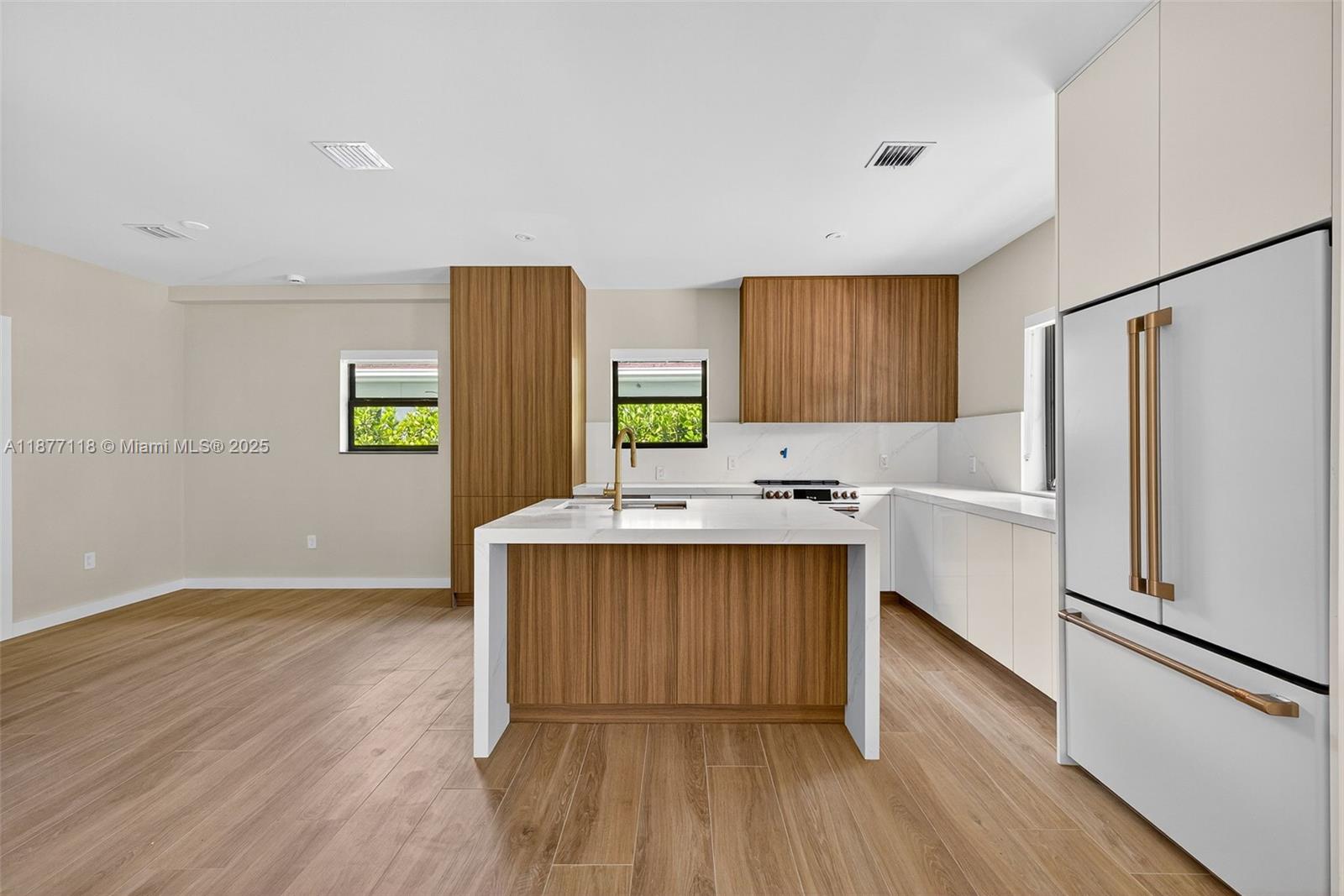 635 Bird Road Coral Gables, FL 33146 - Photo 5 of 25 a kitchen with a wooden floor and a refrigerator