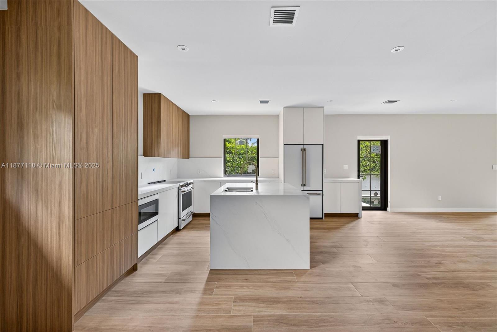 635 Bird Road Coral Gables, FL 33146 - Photo 6 of 25 a view of a kitchen with refrigerator and wooden floor
