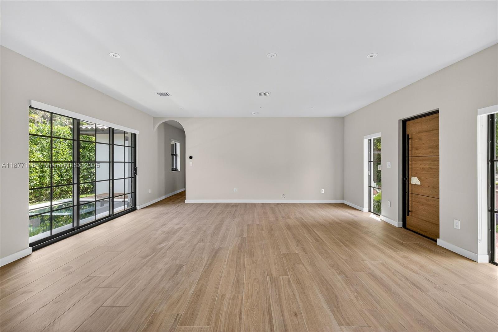 635 Bird Road Coral Gables, FL 33146 - Photo 7 of 25 a view of an empty room with wooden floor and windows