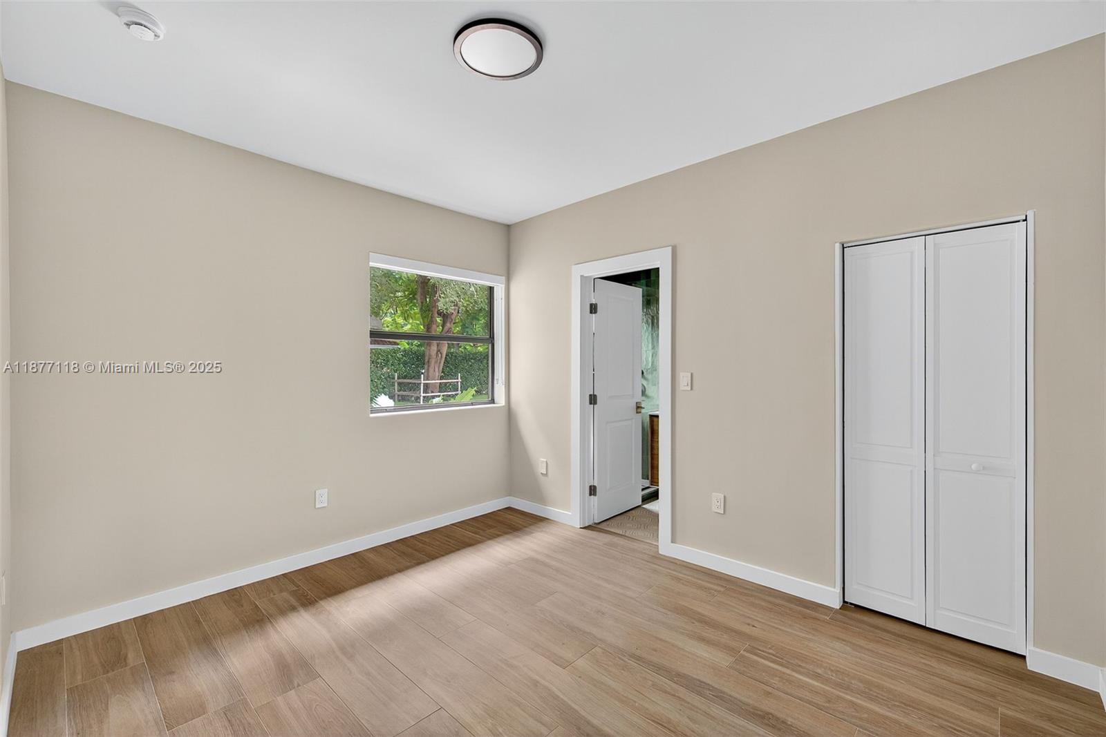 635 Bird Road Coral Gables, FL 33146 - Photo 8 of 25 an empty room with wooden floor and windows