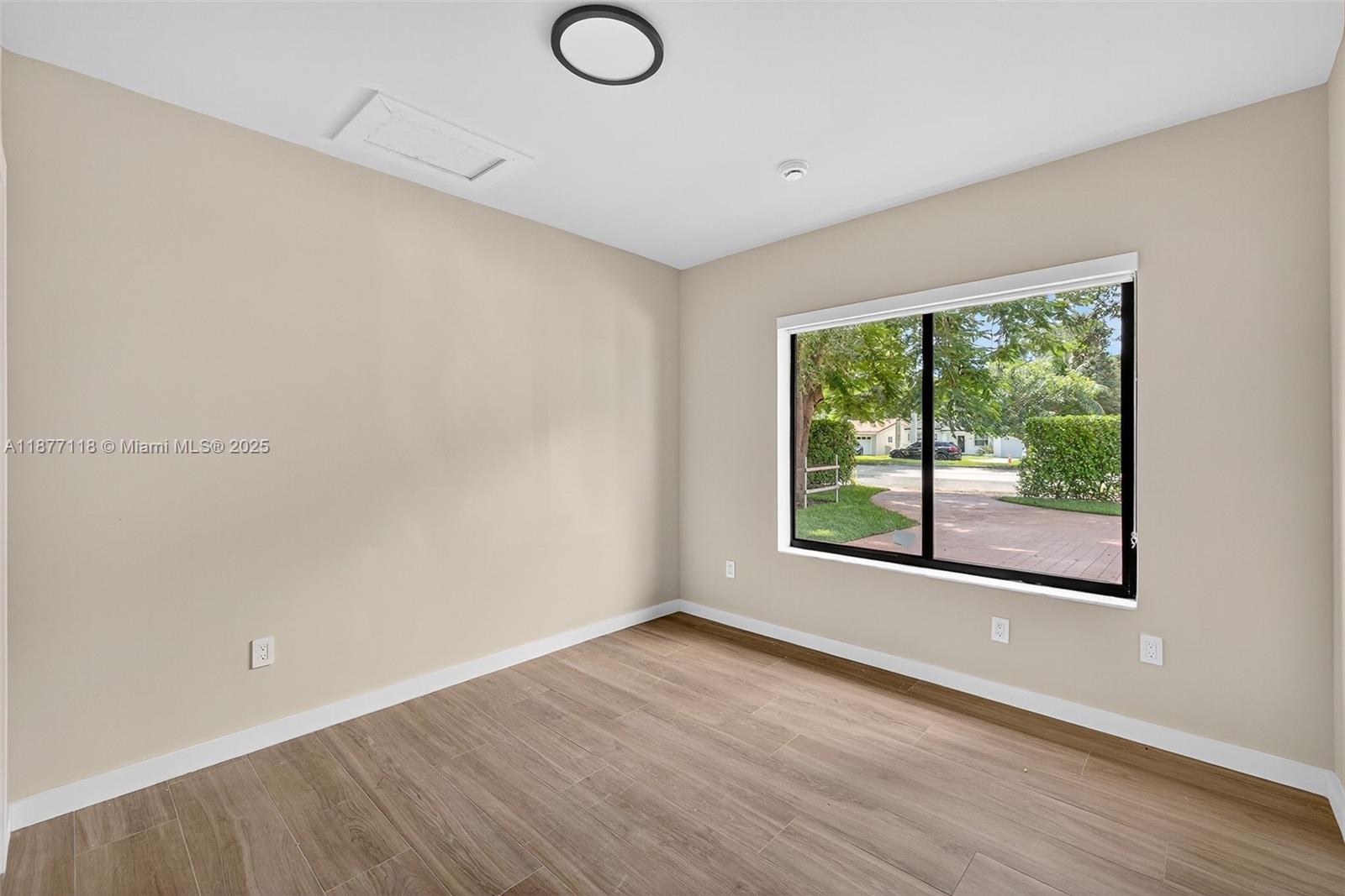 635 Bird Road Coral Gables, FL 33146 - Photo 10 of 25 a view of an empty room with wooden floor and a window