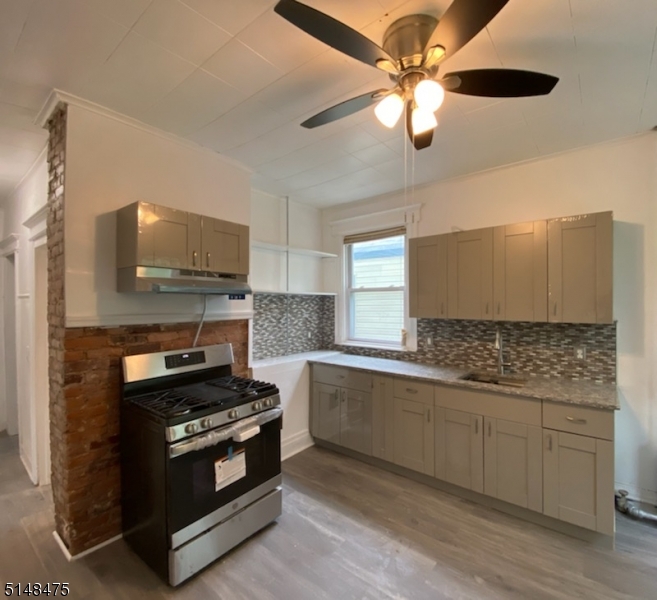 46 Prospect Street, Unit 2 Bloomfield, NJ 07003 - Photo 24 of 33 a kitchen with stainless steel appliances kitchen island granite countertop a stove a sink and a microwave