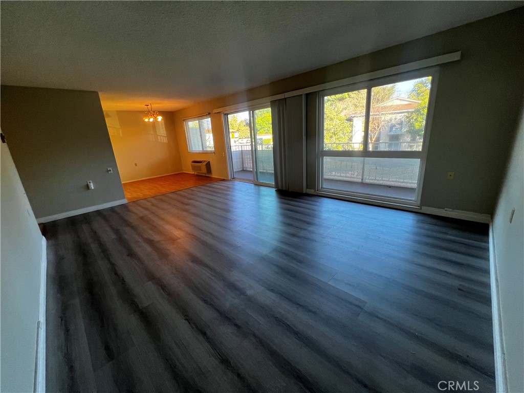 863 Ronda Mendoza, Unit B Laguna Woods, CA 92637 - Photo 11 of 37 an empty room with wooden floor and windows