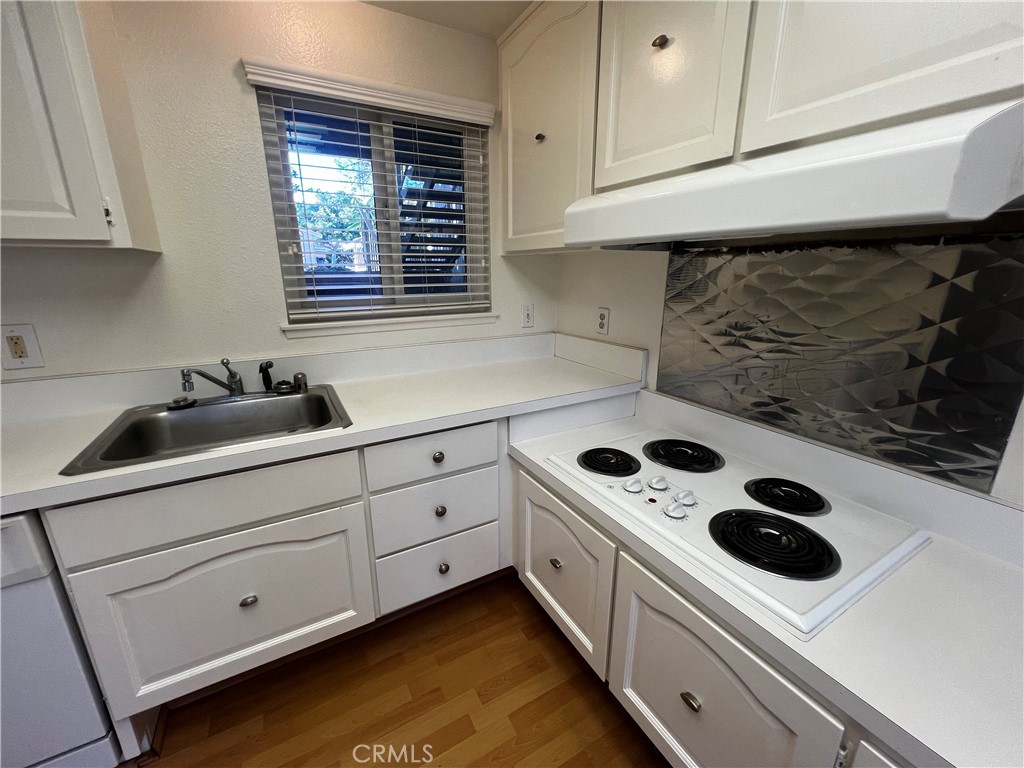863 Ronda Mendoza, Unit B Laguna Woods, CA 92637 - Photo 24 of 37 a kitchen with white cabinets and white appliances