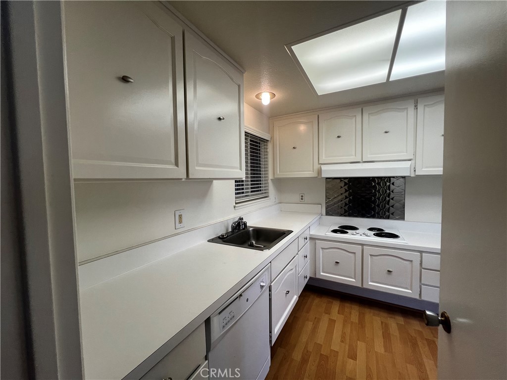 863 Ronda Mendoza, Unit B Laguna Woods, CA 92637 - Photo 26 of 37 a kitchen with a sink a stove and cabinets