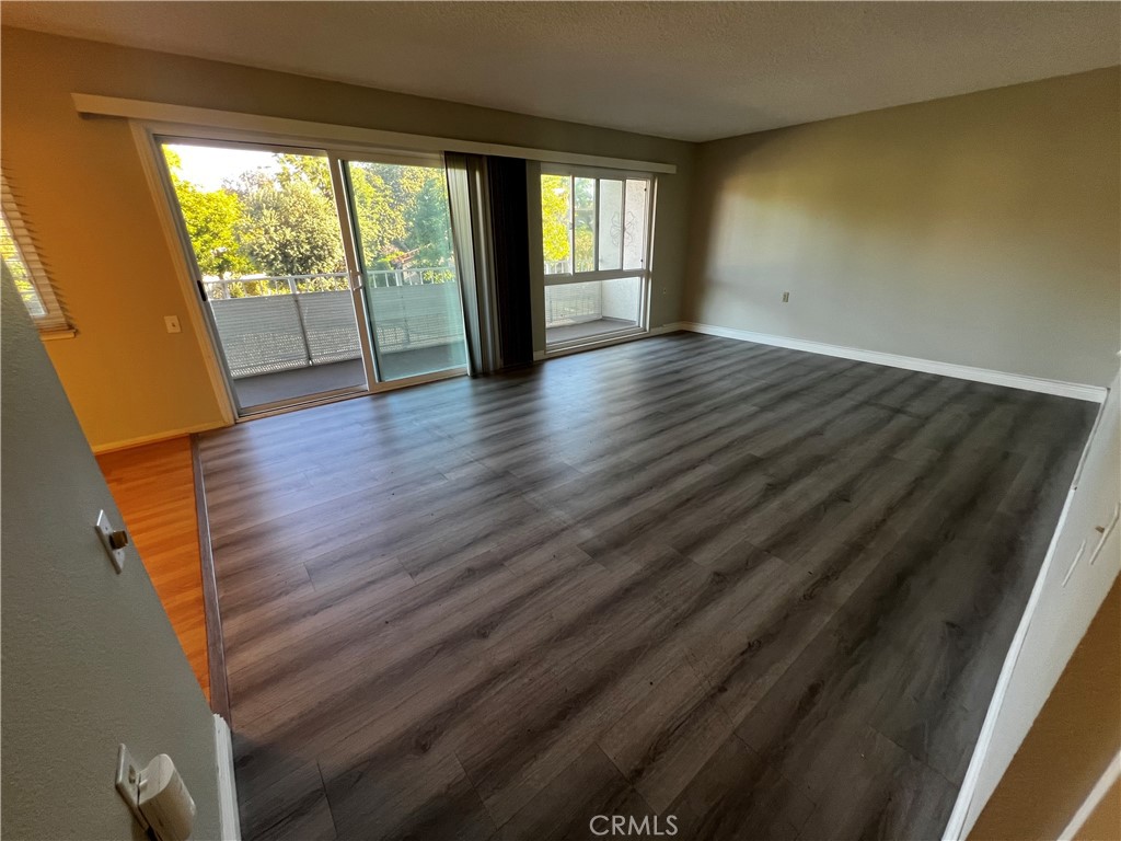863 Ronda Mendoza, Unit B Laguna Woods, CA 92637 - Photo 9 of 37 a view of an empty room with wooden floor and a window