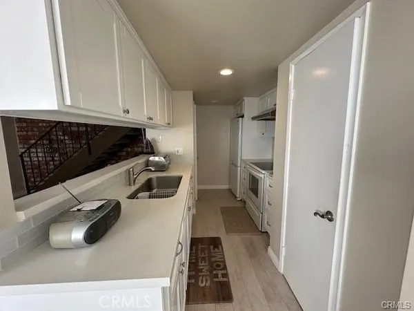 a kitchen with white cabinets and stainless steel appliances