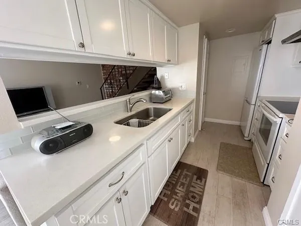 a kitchen with sink a microwave and refrigerator