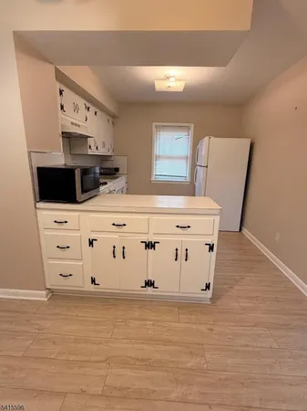 a view of kitchen with cabinets and wooden floor