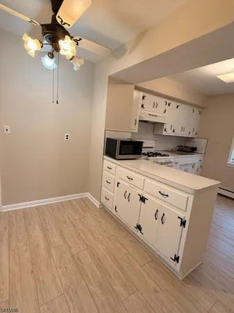 a kitchen with stainless steel appliances a stove a sink and white cabinets