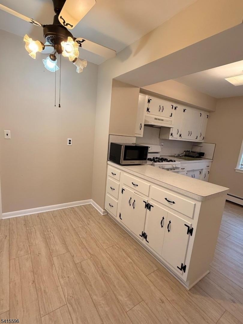401 Raritan Road Linden, NJ 07036 - Photo 3 of 9 a kitchen with stainless steel appliances a stove a sink and white cabinets