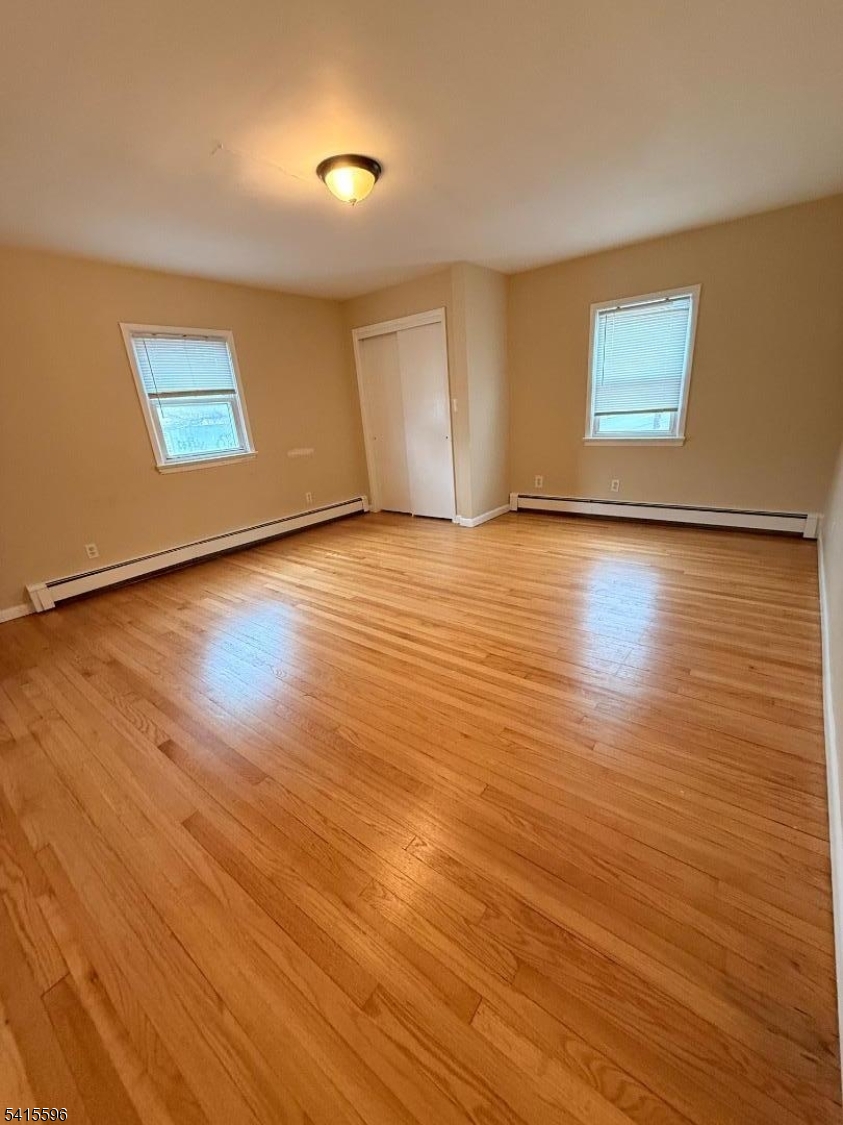 401 Raritan Road Linden, NJ 07036 - Photo 7 of 9 an empty room with wooden floor and windows