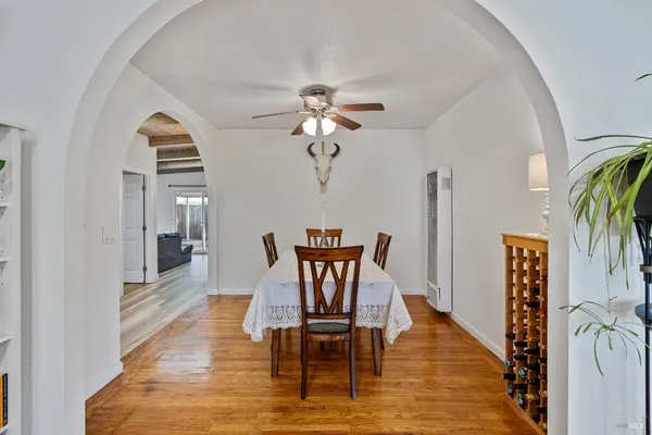 a dining room with furniture a chandelier and wooden floor