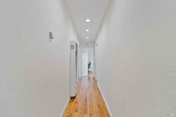 a view of a hallway with wooden floor