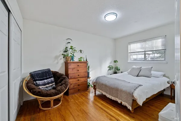 a bedroom with a bed and wooden floor
