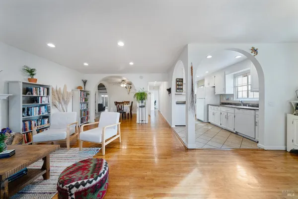 a living room with furniture and view of kitchen