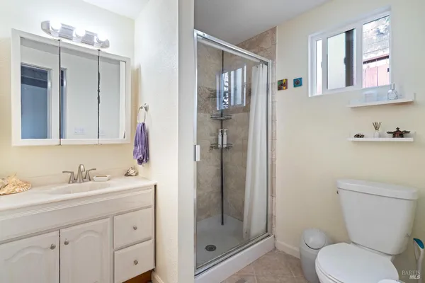 a bathroom with a sink a toilet and shower
