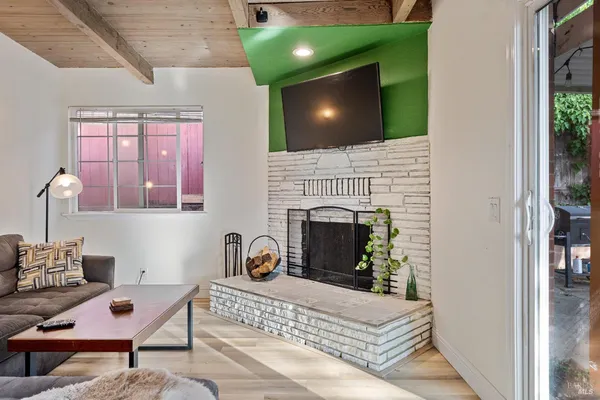 a living room with furniture a flat screen tv and a fireplace