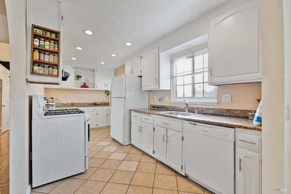 a kitchen with cabinets appliances a sink and a window