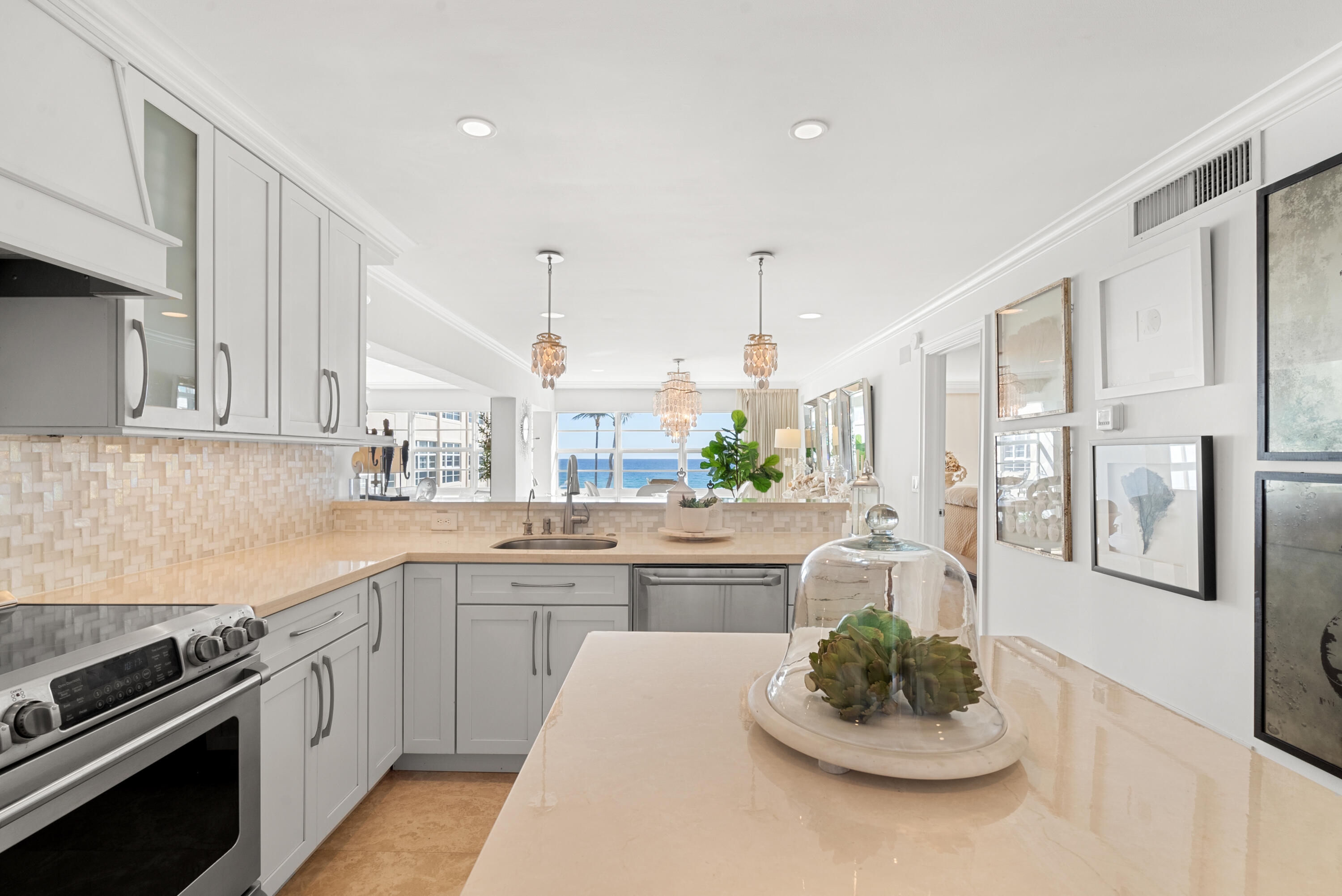 3851 North Ocean Boulevard, Unit 307308 Gulf Stream, FL 33483 - Photo 12 of 26 a kitchen with stainless steel appliances kitchen island granite countertop a sink and cabinets