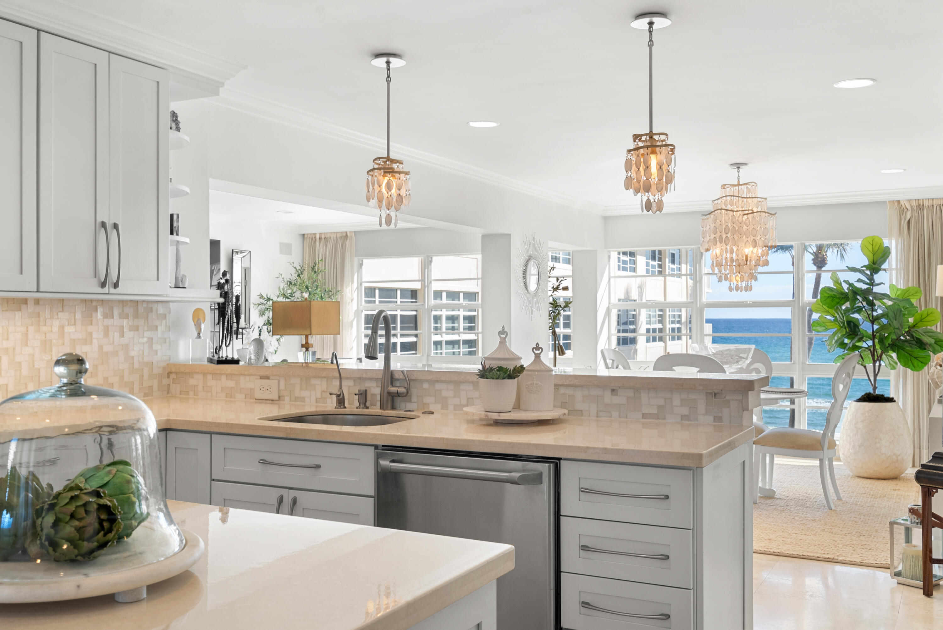3851 North Ocean Boulevard, Unit 307308 Gulf Stream, FL 33483 - Photo 14 of 26 a kitchen with kitchen island granite countertop a white table and chairs