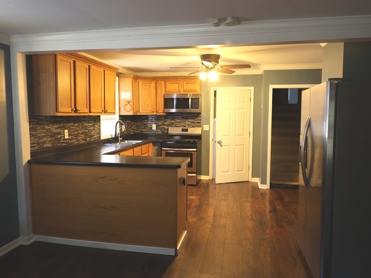 917 North Linden Avenue Waukegan, IL 60085 - Photo 6 of 14 a kitchen with stainless steel appliances granite countertop a refrigerator a stove and a sink with large window