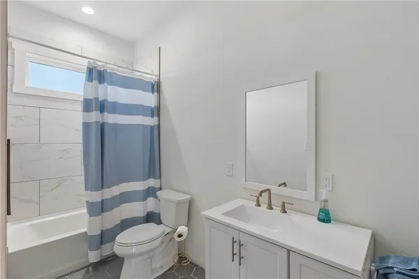 a view of hallway with bathroom and a window
