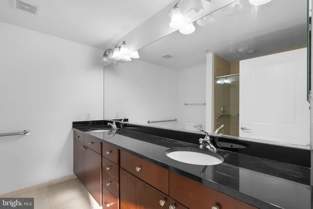 a bathroom with a granite countertop sink a mirror and a light fixture
