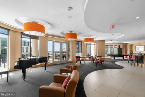 a living room with furniture a fireplace and large windows