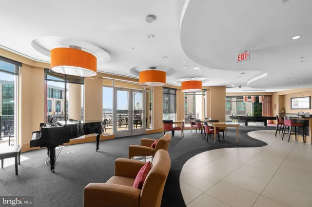 a living room with furniture a fireplace and large windows