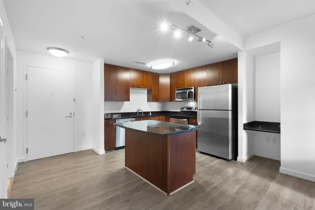 a kitchen with stainless steel appliances granite countertop a refrigerator and a stove