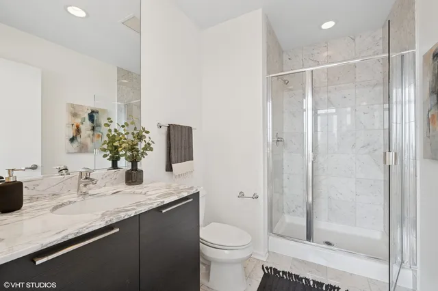 a bathroom with a granite countertop sink toilet and shower