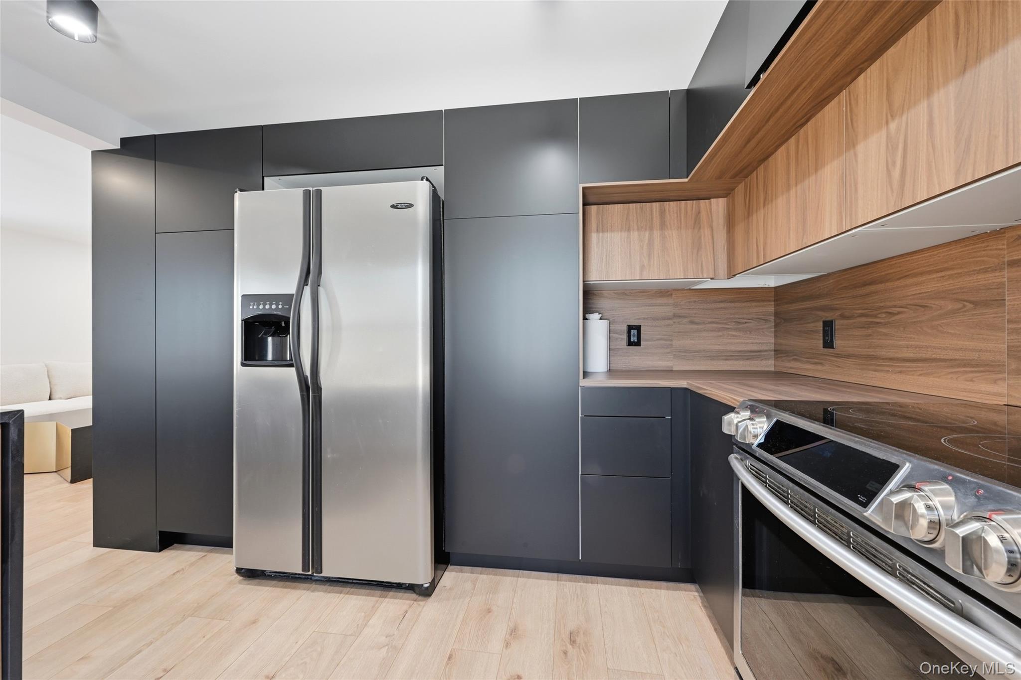 923 East Main Street Riverhead, NY 11901 - Photo 12 of 30 a kitchen with metallic refrigerator and wooden floor