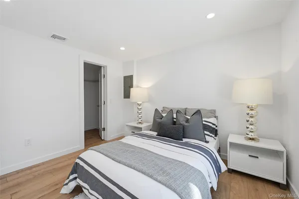 a bedroom with a bed and a lamp on dresser