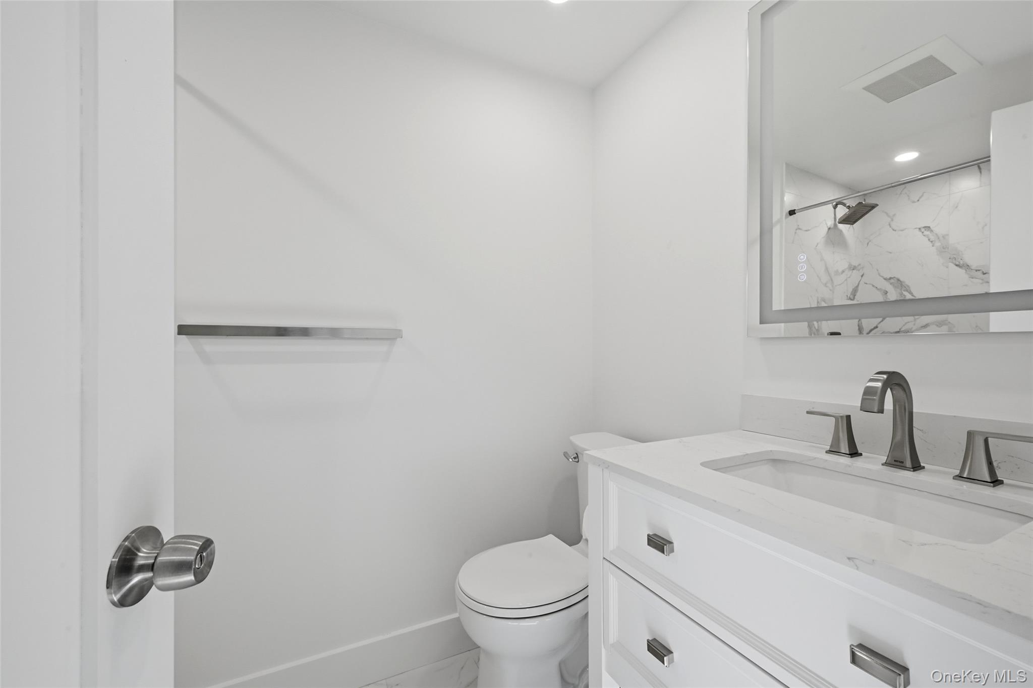 923 East Main Street Riverhead, NY 11901 - Photo 17 of 30 a bathroom with a toilet sink vanity and mirror