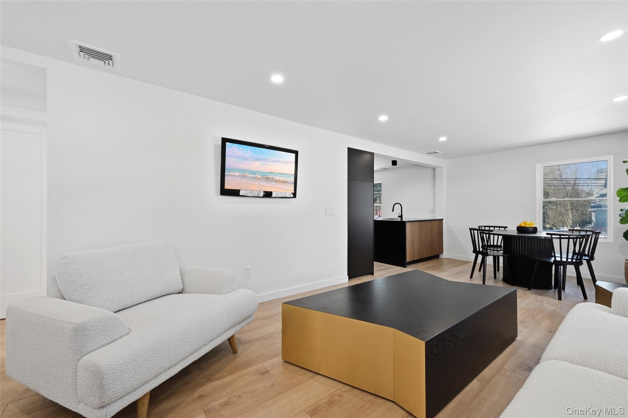 923 East Main Street Riverhead, NY 11901 - Photo 4 of 30 a living room with furniture wooden floor and a kitchen view
