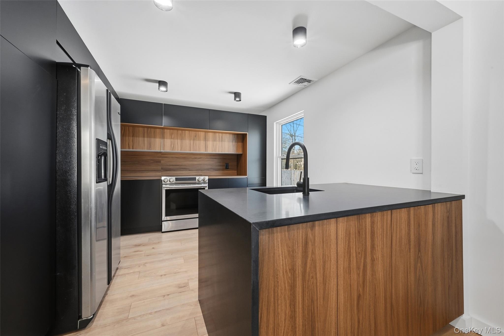 923 East Main Street Riverhead, NY 11901 - Photo 9 of 30 a kitchen with stainless steel appliances a refrigerator and a sink