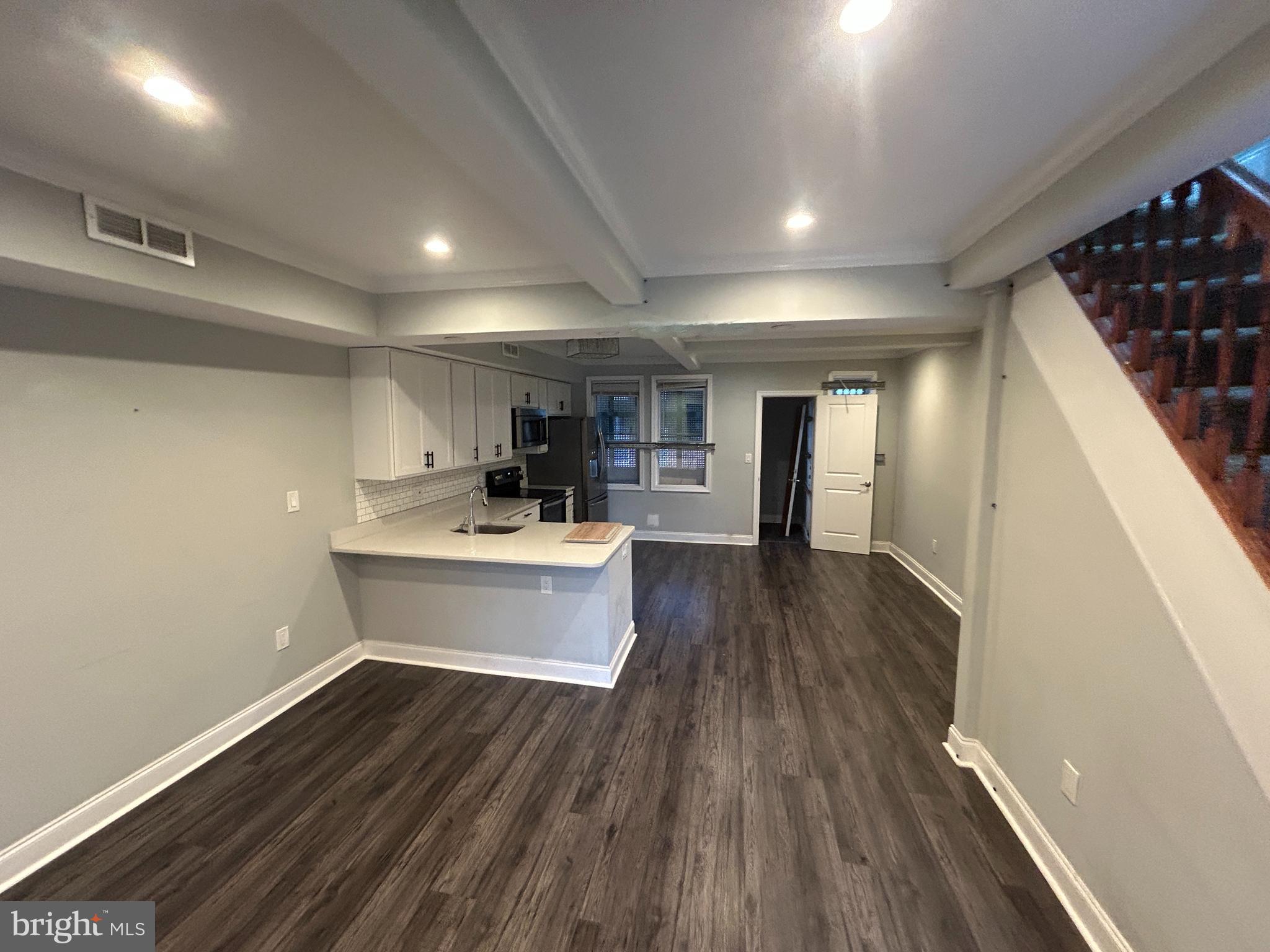 4140 Reisterstown Road Baltimore, MD 21215 - Photo 5 of 18 a view of a kitchen with a sink and wooden floor