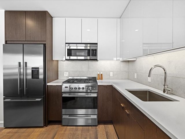 a kitchen with stainless steel appliances granite countertop a sink stove and refrigerator