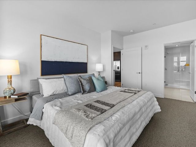 a large bed sitting in a bedroom next to a lamp and a lamp