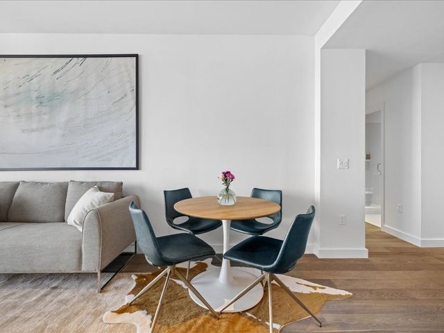 a living room with furniture and a dining table with wooden floor