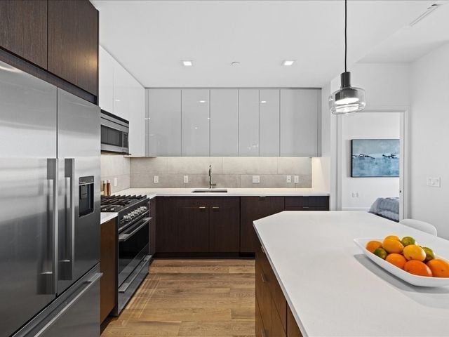 a kitchen with stainless steel appliances granite countertop a sink stove and refrigerator