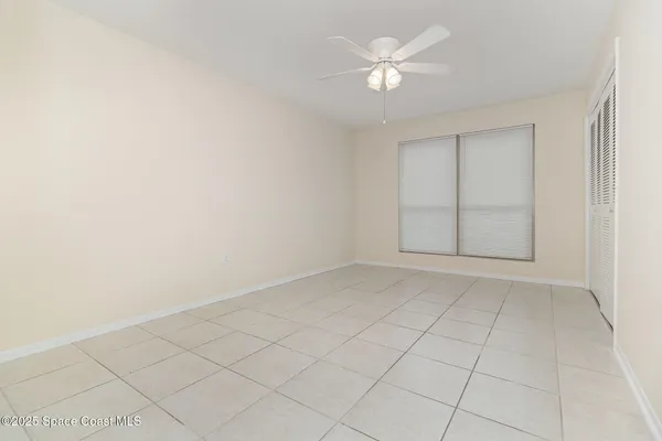 an empty room with white cabinet and a ceiling fan