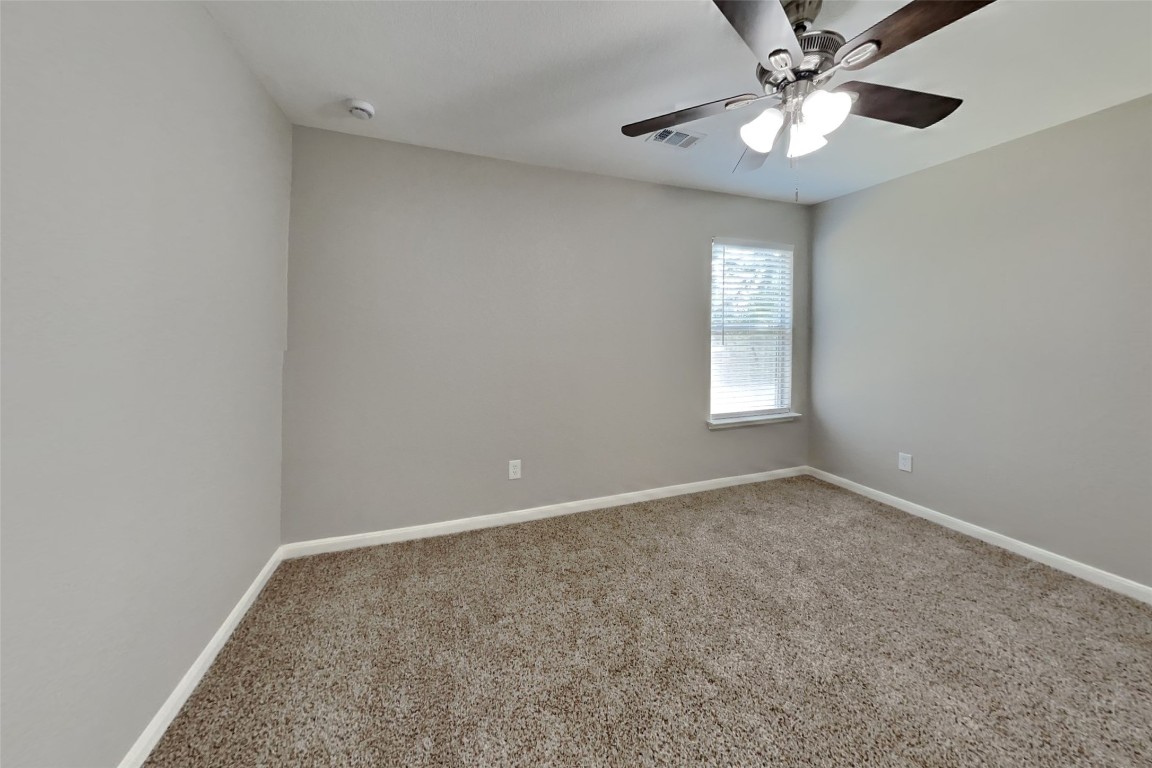 6423 Lily Hollow Court Spring, TX 77379 - Photo 11 of 20 an empty room with a chandelier fan and windows